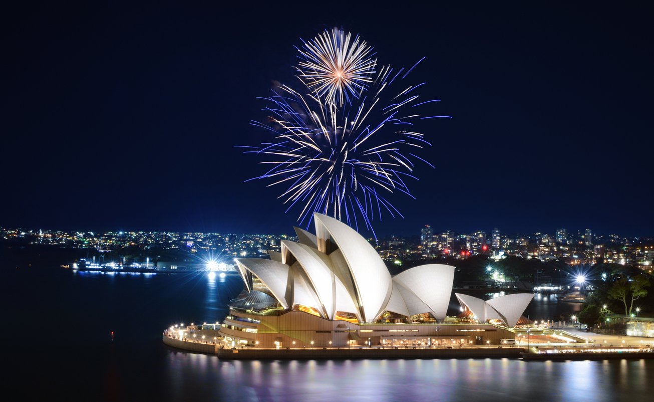 spectacle de feux d’artifice illuminent le ciel en bleu et blanc sur l’Opéra de Sydney